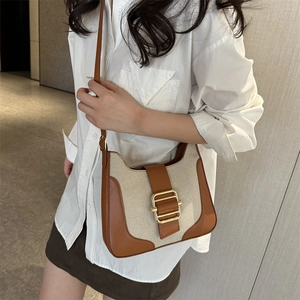Sac hobo rétro en toile et cuir marron porté par un mannequin dans un cadre minimaliste