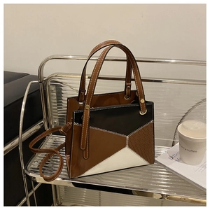 Detail of tricolor geometric stitching on a medium crossbody bag with zigzag seam details