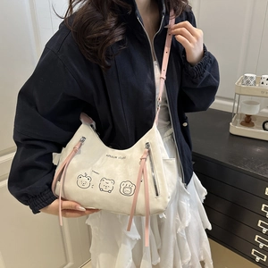 White teddy bear print shoulder bag with pink leather strap shown on a model