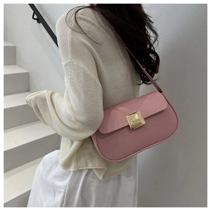 Detail of a pink minimalist shoulder bag featuring a gold metal square buckle on matte leather