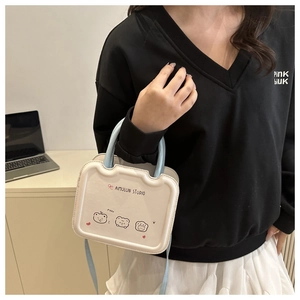 Detail of white mini square bag featuring cute cartoon bears and light blue top handles
