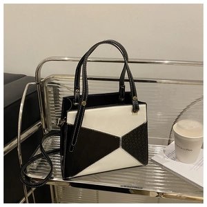 Detail showing high-contrast black and white patchwork tote with crocodile texture
