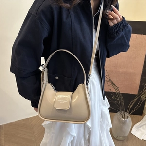 Minimalist beige moon bag in glossy leather with double straps and fashion engraving