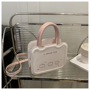 Detail of pink and white crossbody bag with cute cartoon bear prints on a rack
