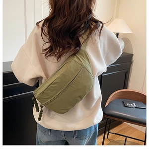 Detail of olive green crescent crossbody bag with woven rope zipper on casual nylon fabric