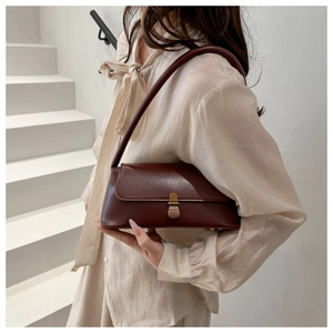 Macro detail of dark brown vintage leather handbag with a retro golden metal buckle