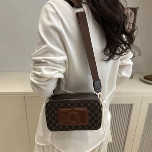 Sac caméra marron à monogramme avec logo G et large bandoulière sur le modèle