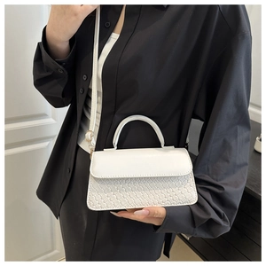 White vintage crossbody bag featuring a woven texture detail and a sleek top leather flap
