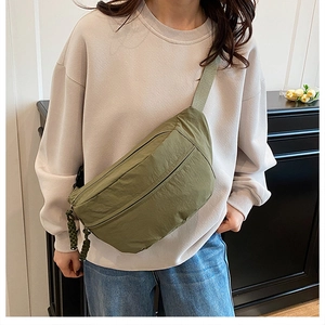 Detail view of army green nylon crossbody bag with dual zippers and adjustable wide strap
