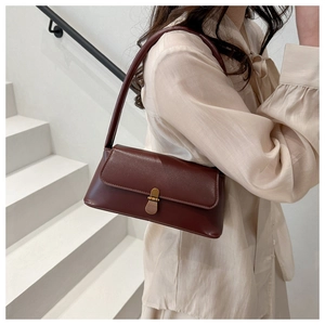 Close-up of brown vintage rectangle shoulder bag featuring a brass metal clasp detail