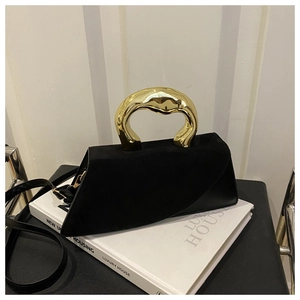 Detail of black geometric crossbody bag with a modern sculptural gold metal handle