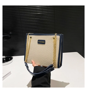 Détail du sac à main tissé avec garniture en cuir bleu et bandoulière en chaîne dorée