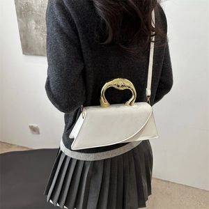 Minimalist white trapezoid crossbody bag with artistic gold handle and leather strap