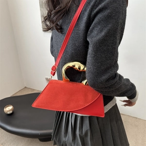 Minimalist red suede geometric handbag with gold streamlined handle and leather strap