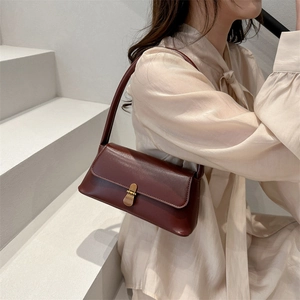 French vintage dark red leather underarm bag with gold metal buckle shown on a model