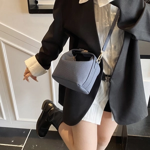 Sac oreiller bleu texturé chic avec fine bandoulière porté par un mannequin en style décontracté