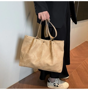 Detail of khaki tote bag with metal chain handle and soft suede texture finish
