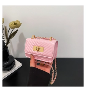 Detail of pink V-quilted crossbody bag with gold chain strap and metal swivel lock