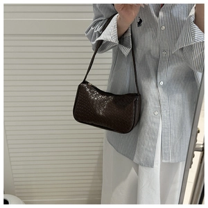 Detailed view of the dark brown woven texture on this elegant faux leather crossbody bag
