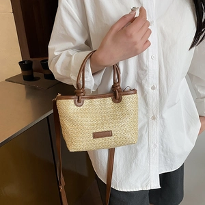 Mini straw woven bucket bag with brown leather trim and handles for vacation