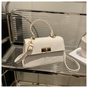 Detailed macro view of white marble texture leather bag with gold twist lock and handle