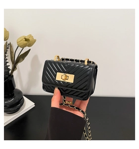 Detail of black V-quilted mini chain bag with gold hardware and square turn lock