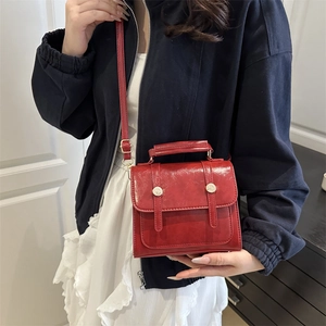Sac bandoulière rouge rétro en cuir brillant avec deux lanières et une poignée