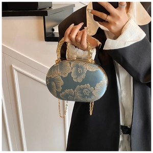 Dettaglio della borsa da sera ovale blu con ricami floreali dorati e chiusura strass