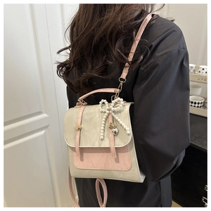 Détail du sac à dos de style coréen avec contraste rétro vert et rose et noeud perlé