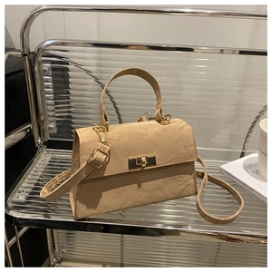 Detail of beige pleated leather texture and gold twist lock on the structured crossbody bag
