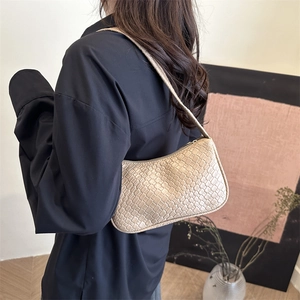 Elegant beige woven square shoulder bag with minimalist flap design worn by a model