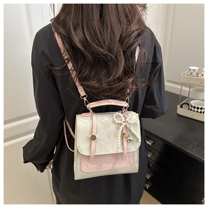 Détail d'un mini sac à dos en cuir bicolore avec breloque perle et boucle en métal