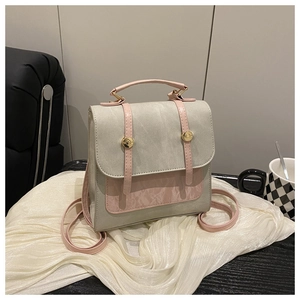 Détail du sac à dos bicolore vert-gris et rose avec boucles dorées et texture en similicuir