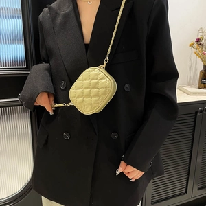 Chic quilted lime green mini crossbody bag with gold chain strap shown on model in black suit