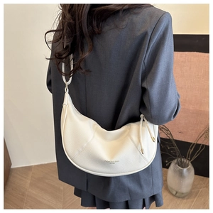 Detail of white lychee leather half-moon bag with adjustable strap and fashion lettering