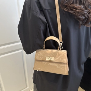 Minimalist beige pleated crossbody bag with gold twist lock and chic top handle