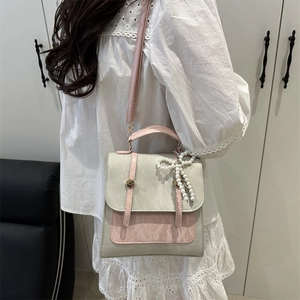 Sac à dos chic rose et gris avec breloque nœud en perles et poignée de transport