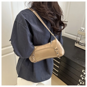 Detail of khaki shoulder bag with adjustable strap and decorative metal buckles