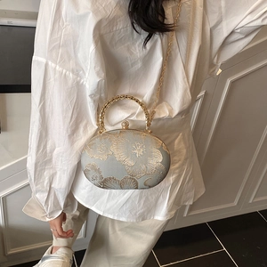 Borsa ovale in raso blu con ricami floreali dorati e chiusura con strass brillanti