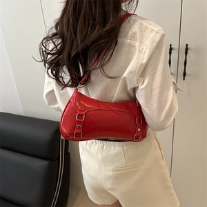 Fashionable red glossy patent leather baguette shoulder bag with metallic buckle detail