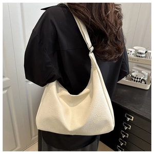 Close-up of off-white faux leather tote bag showing soft texture and shoulder strap