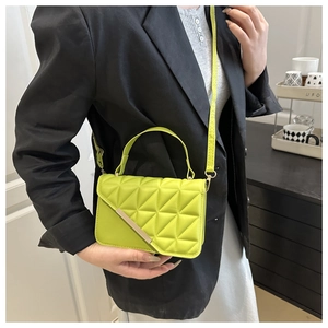 Detail of neon green small square bag with geometric triangle quilting and gold metal bar