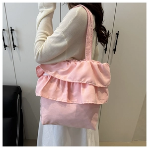 Pink canvas tote bag featuring double-layered ruffle accents and a minimalist shoulder strap