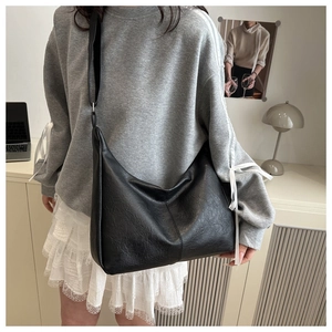 Detail of the black large-capacity tote bag in lychee pattern faux leather on model