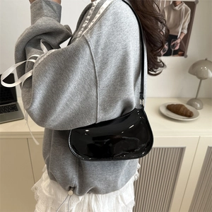 Chic black patent leather crescent shoulder bag with high-gloss finish and slim strap