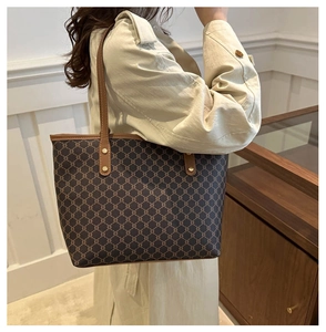 Détail du sac cabas vintage avec motifs géométriques et poignées en cuir marron
