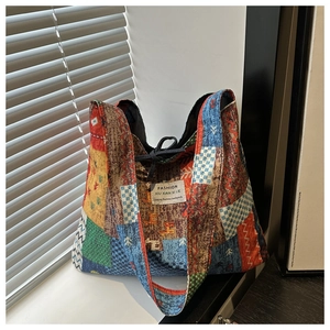 Detailed patchwork canvas tote bag with ethnic patterns and black drawstring closure