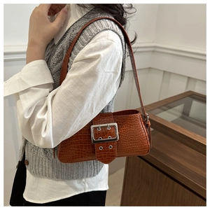 Detail of vintage reddish brown crocodile pattern underarm bag with silver square buckle