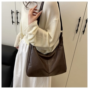 Close-up of deep brown tote bag with vintage pleated leather texture and metal zipper