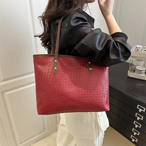 Minimalist red woven tote bag with brown leather handles and gold rivet accents for work